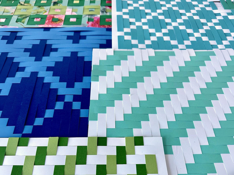 Make-&-Mingle_3 Close-up of colourful woven paper mats in blue, green, and white patterns, a “Make & Mingle” craft activity that encourages creativity and connection.