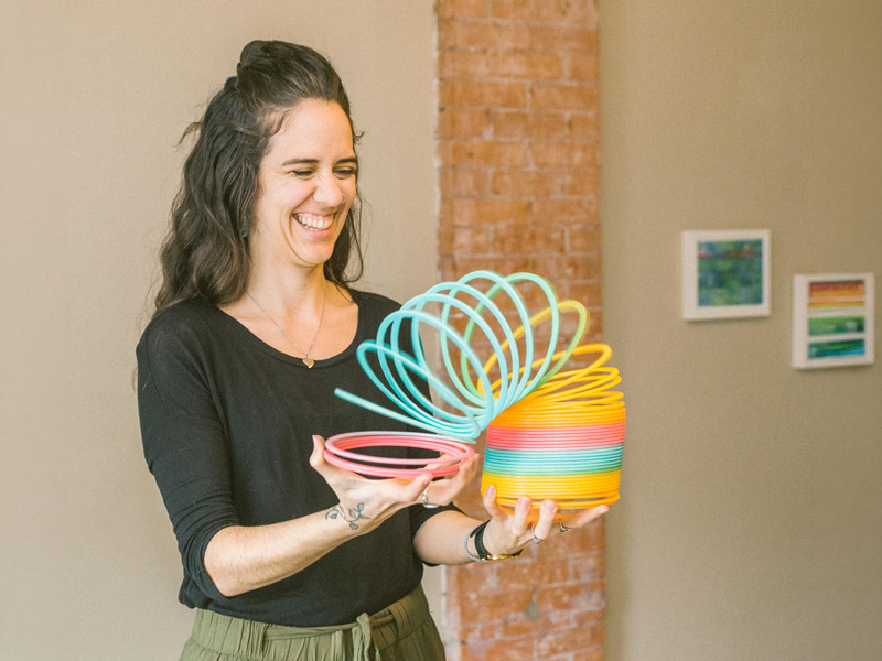 Moving-&-Grooving_2 Facilitator holds a bright rainbow slinky during a “moving and grooving” activity, creating a playful, welcoming space for connection and self-expression.